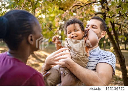 Joyful family moment under autumn trees in a park Joyful family moment under autumn trees in a park 135136772