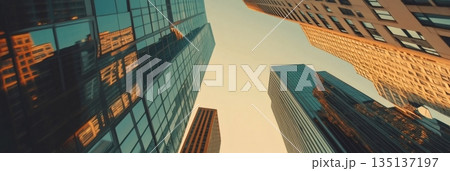 Warm sunlight illuminates the glass facades of towering skyscrapers in a bustling metropolis, creating a dynamic and inspiring urban landscape 135137197