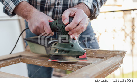 Carpenter at work, restoring an old wooden window. Carpentry. Carpenter at work, restoring an old wooden window. Carpentry. 135138052