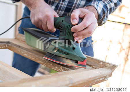 Carpenter at work, restoring an old wooden window. Carpentry. Carpenter at work, restoring an old wooden window. Carpentry. 135138053