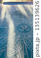 Yoga mat with Om symbol in soft morning light 135139626