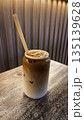 Iced latte coffee in glass jar on wooden table in cafe 135139628