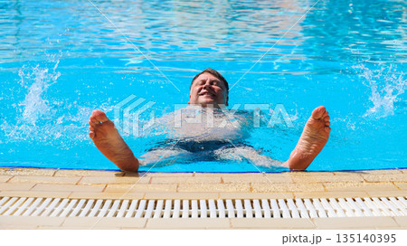 Adult Man Floating on His Back in the Pool of an Egyptian Hotel, Enjoying a Relaxing Day Under the Sun in a Tropical Paradise Adult Man Floating on His Back in the Pool of an Egyptian Hotel, Enjoying a Relaxing Day Under the Sun in a Tropical Paradise 135140395