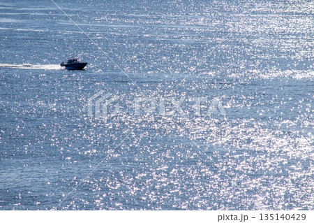 キラキラ光る海面を航行する船 135140429