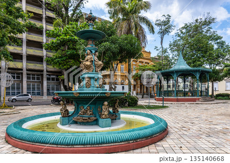 Fountain at Praca Dom Pedro II square in Manaus, Brazil on a Sunny Day with Mosaic Pavement and Lush Trees 135140668