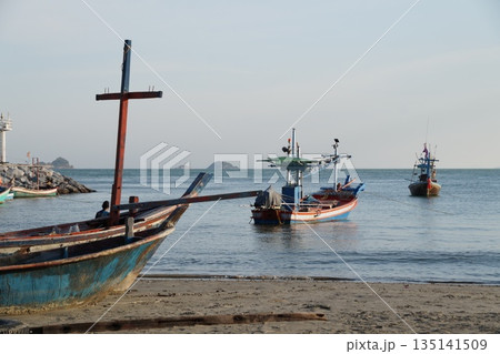 Fishing boats in the sea. Several wooden, colorful fishing boats are standing in the sea near the shore. 135141509