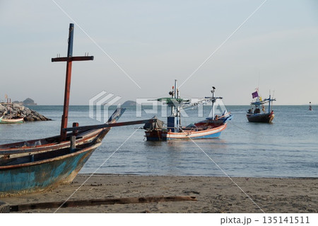 Fishing boats at sea.Fishing boats in the sea. Several wooden, colorful fishing boats are standing in the sea near the shore. 135141511