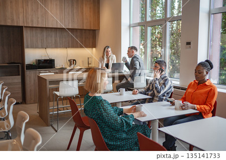Group of People Sitting Around Table in Room Group of People Sitting Around Table in Room 135141733