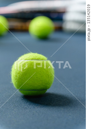 Tennis ball on blue court with racket 135142019