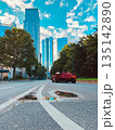 Modern city street with skyscrapers and red sports car 135142890