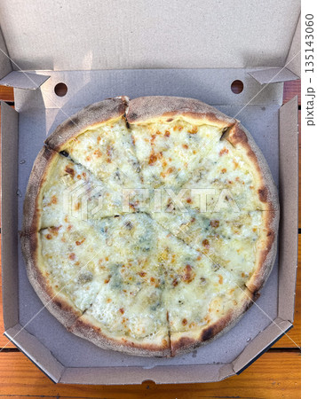 Cheese pizza with a golden crust in an open takeout box. 135143060