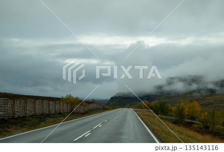 Empty autumn road through colorful forest in Finnish Lapland Empty autumn road through colorful forest in Finnish Lapland 135143116