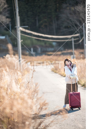 キャリーケースを引っ張る若い女性 キャリーケースを引っ張る若い女性 135143470