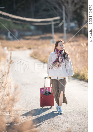 キャリーケースを引っ張る若い女性 キャリーケースを引っ張る若い女性 135143479