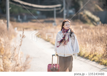 キャリーケースを引っ張る若い女性 キャリーケースを引っ張る若い女性 135143480
