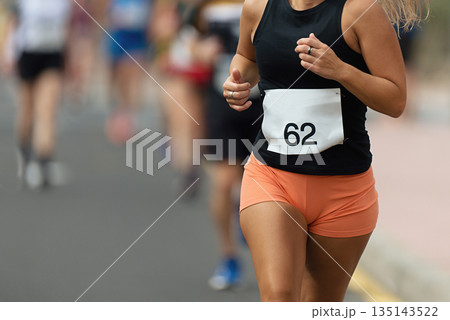 Woman runner running on marathon race on sunny days 135143522