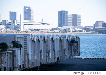 トレーラーの並ぶ港と東京湾越しのビル群 トレーラーの並ぶ港と東京湾越しのビル群 135143716