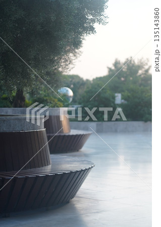 Contemporary Outdoor Seating Arrangement Surrounded by Lush Greenery and Soft Light Creating a Calm Ambiance for Relaxation and Reflection 135143860