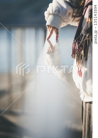 海辺に立つ女性の手元 海辺に立つ女性の手元 135143894