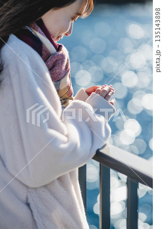 海辺に立つ女性の手元 海辺に立つ女性の手元 135143898