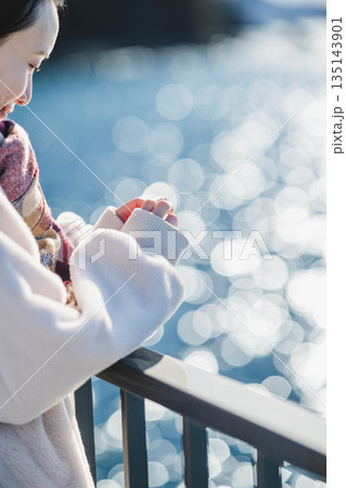 海辺に立つ女性の手元 海辺に立つ女性の手元 135143901