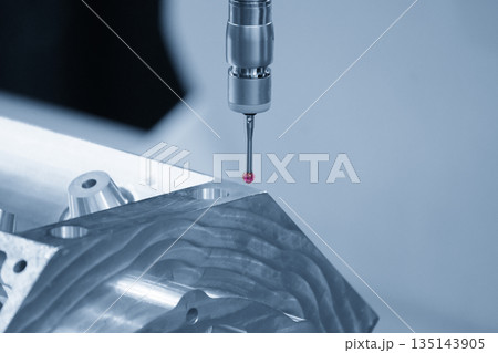 The multi-axis CMM machine measuring the aluminum cylinder head parts in the light blue scene. 135143905