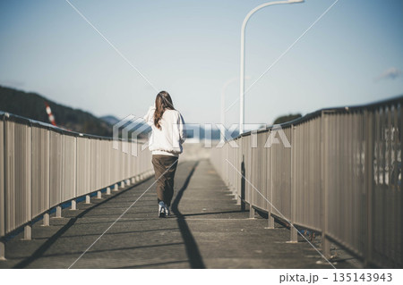 海辺を歩く若い女性 135143943