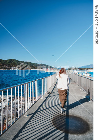 海辺を歩く若い女性 135143946