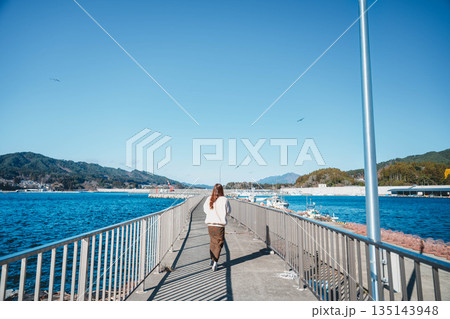 海辺を歩く若い女性 海辺を歩く若い女性 135143948