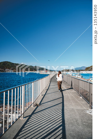 海辺を歩く若い女性 海辺を歩く若い女性 135143950