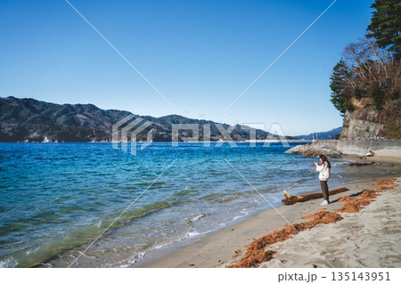 海辺を歩く若い女性 135143951