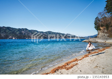 海辺を歩く若い女性 海辺を歩く若い女性 135143953