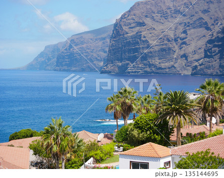 Ocean Cliffs and Terracotta Roofs in Tropical Coastal Town, Spain, Tenerife, Los Gigantes 135144695
