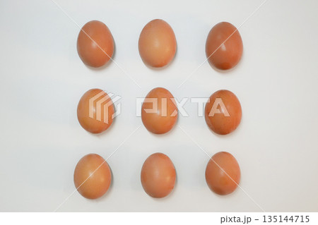 Minimalistic flat lay of brown chicken eggs on white background. Minimalistic flat lay of brown chicken eggs on white background. 135144715
