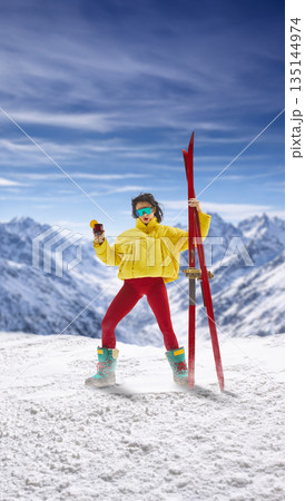 Stylish collage. Woman posing with skis and winter drink in mountains. 135144974