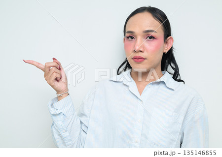 Portrait of a young Thai transgender person pointing finger against white background 135146855