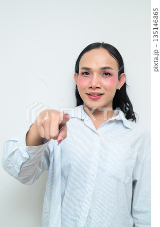 Portrait of a young Thai transgender person pointing finger against white background 135146865