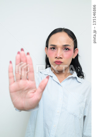 Portrait of a young Thai transgender person showing STOP with hand gesture against white background 135146866