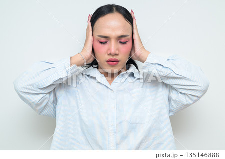 Portrait of a young Thai transgender person covering ears against white background Portrait of a young Thai transgender person covering ears against white background 135146888