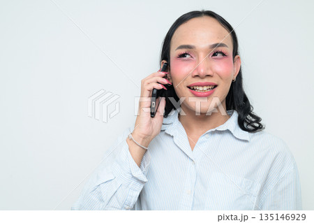 Portrait of a young Thai transgender person on the phone against white background 135146929