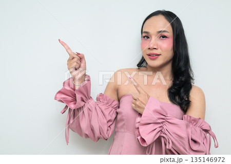 Portrait of a young Thai transgender person against white background pointing finger Portrait of a young Thai transgender person against white background pointing finger 135146972