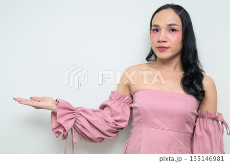 Portrait of young Thai transgender person against white background presenting and showing something Portrait of young Thai transgender person against white background presenting and showing something 135146981