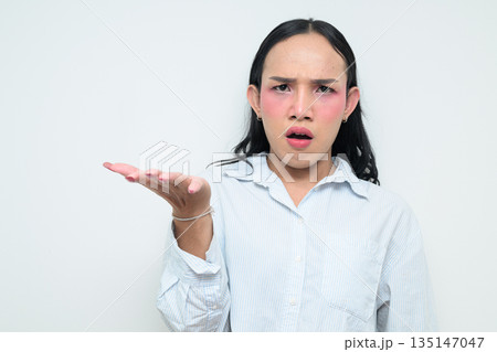 Portrait of a young angry Thai transgender person shrugging against white background 135147047