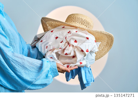Person carrying laundry and straw hat with heart pattern Person carrying laundry and straw hat with heart pattern 135147271