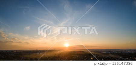 Bright colorful sunset sky with setting sun and vivid soft clouds. Concept of nature and environment Bright colorful sunset sky with setting sun and vivid soft clouds. Concept of nature and environment 135147356