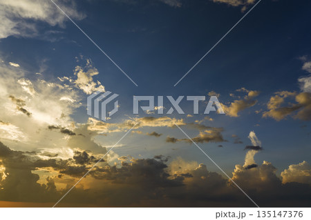 Beautiful sunset sky scenery. Bright colorful orange and yellow clouds on horizon 135147376
