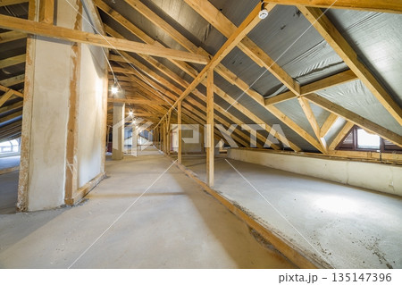 Attic of a building with wooden beams of a roof structure. Attic of a building with wooden beams of a roof structure. 135147396