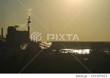 Aerial view of wood processing factory with smoke from productio 135147425