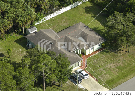 Aerial view of typical contemporary american private house with roof top covered with asphalt shingles and green lawn on yard Aerial view of typical contemporary american private house with roof top covered with asphalt shingles and green lawn on yard 135147435
