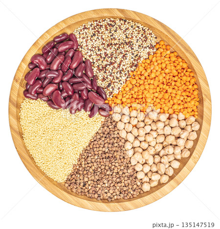 Assorted healthy grains and legumes in round wooden plate isolated on white background, top view 135147519